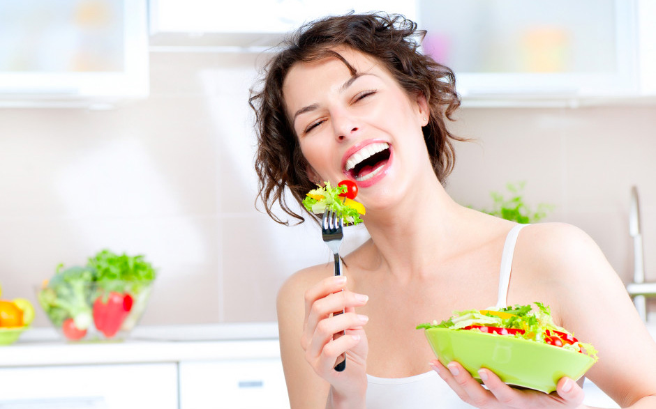 Женщина смеётся с салатом